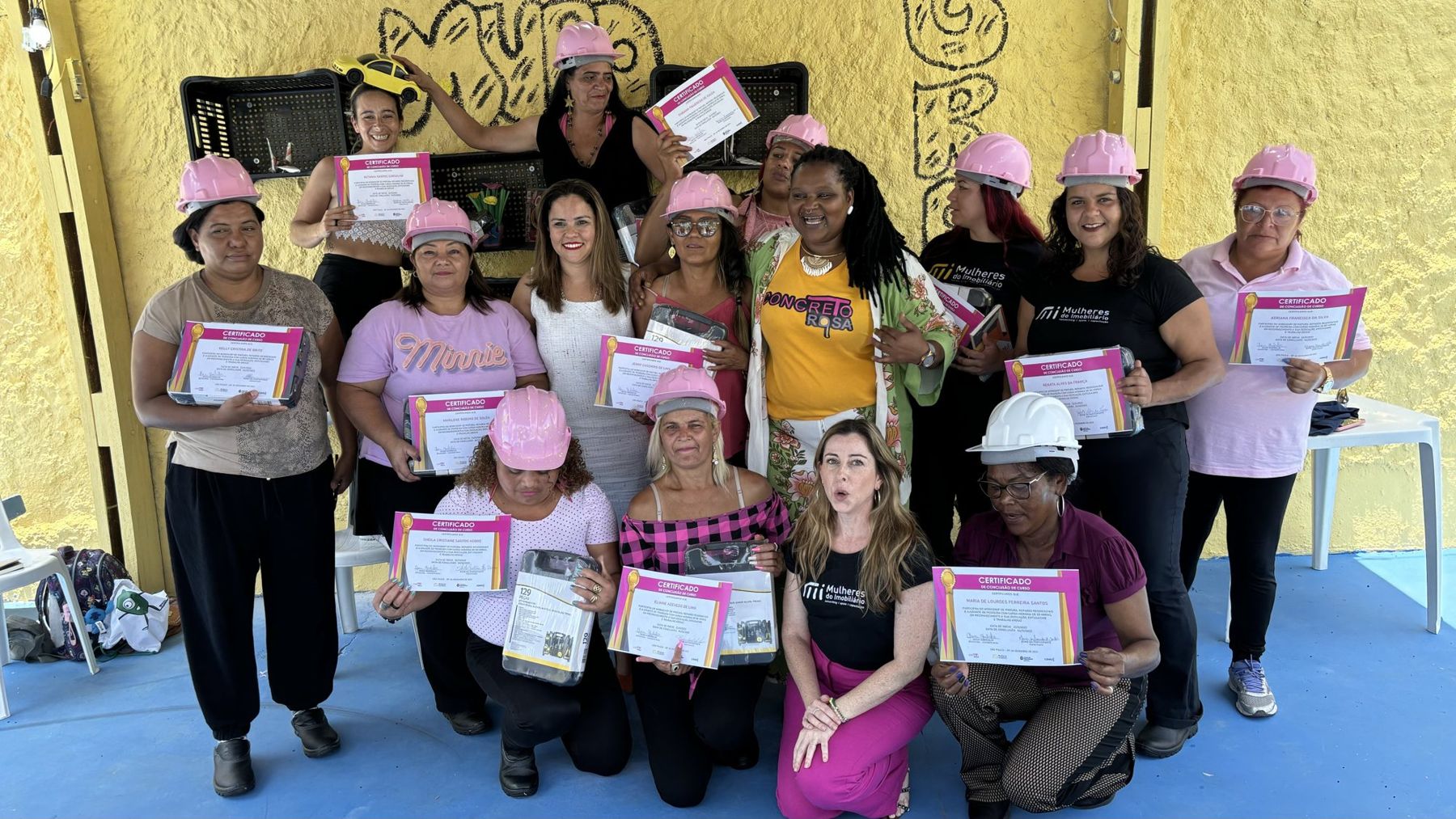 Formatura das participantes do Capacita Concreto Rosa, com capacetes cor-de-rosa e certificados