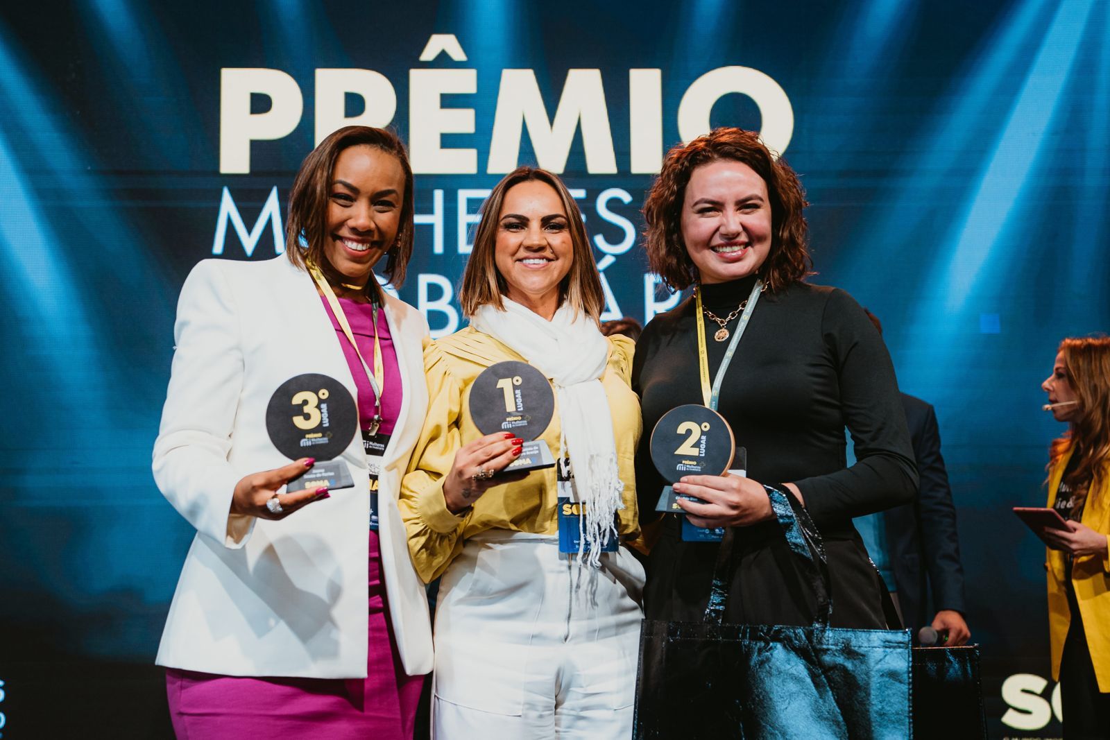 Vencedoras do Prêmio Mulheres do Imobiliário 2023 com seus troféus no palco do SOMA